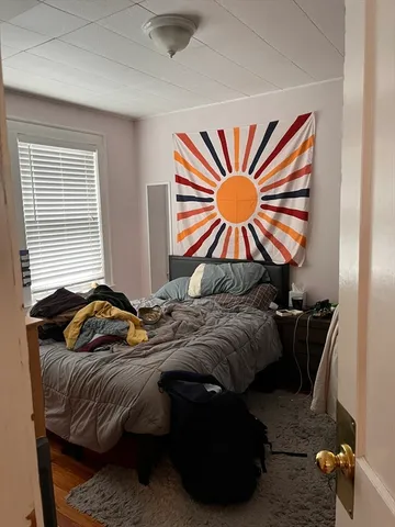 a bedroom with a bed and a painting on the wall