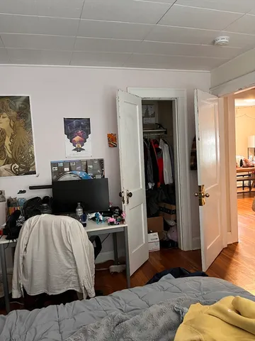 a bedroom with a bed and wooden floor