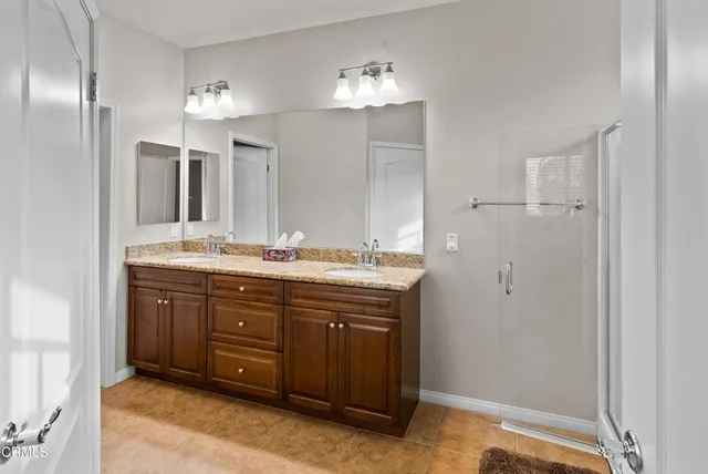 a bathroom with a double vanity sink and a mirror
