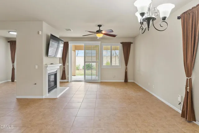 a view of a livingroom with a chandelier fan and windows