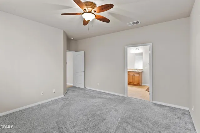 an empty room and chandelier fan