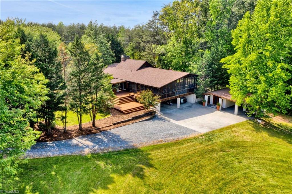7762 Eversfield Road Summerfield, NC 27358 - Photo 6 of 30 Another Drone picture from the rear of the property showing the huge screened porch, carports and utility building built in 2019 with additional carport/tractor shed.