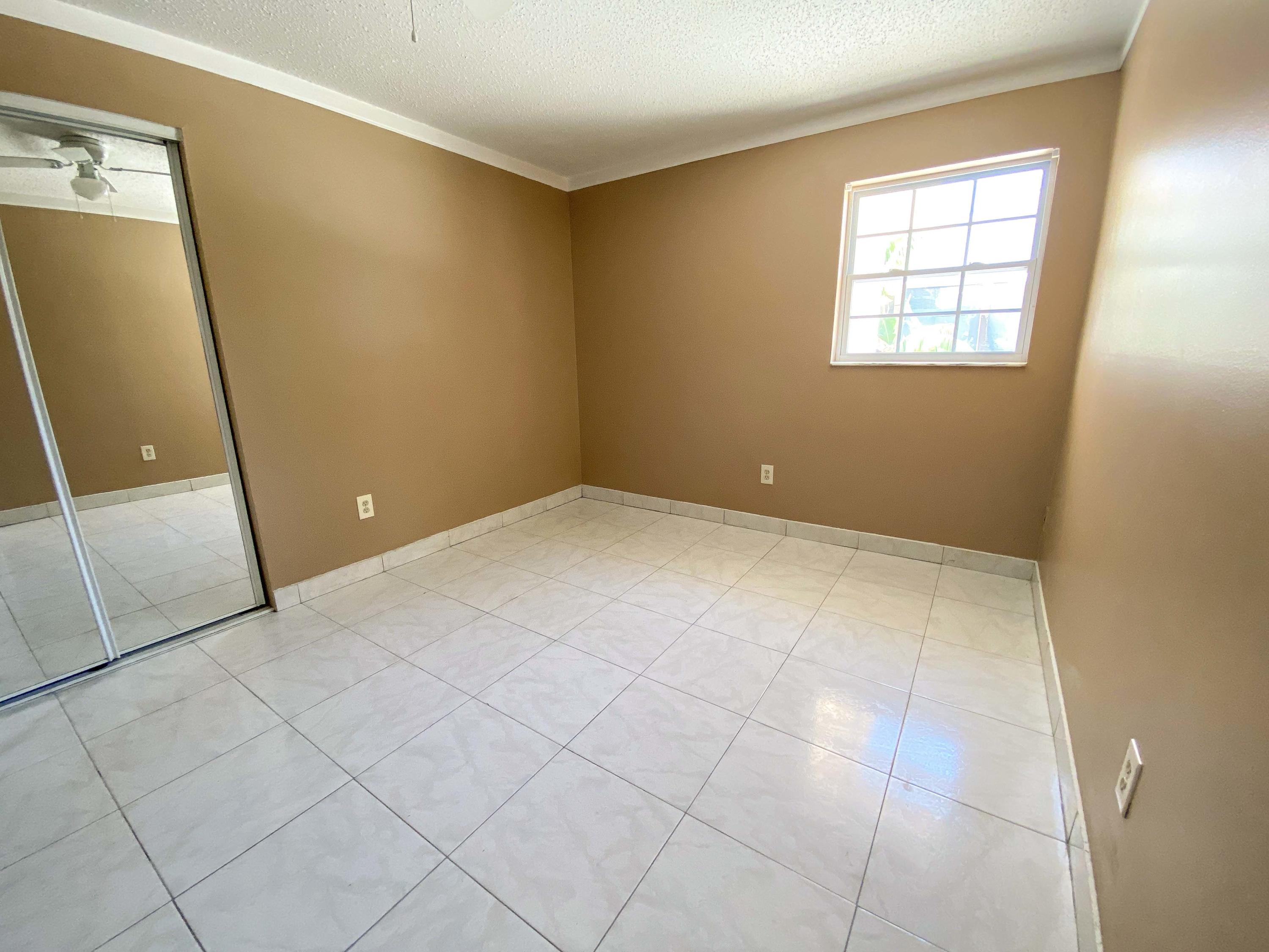 5884 Mango Road, Unit B West Palm Beach, FL 33413 - Photo 5 of 8 an empty room with windows