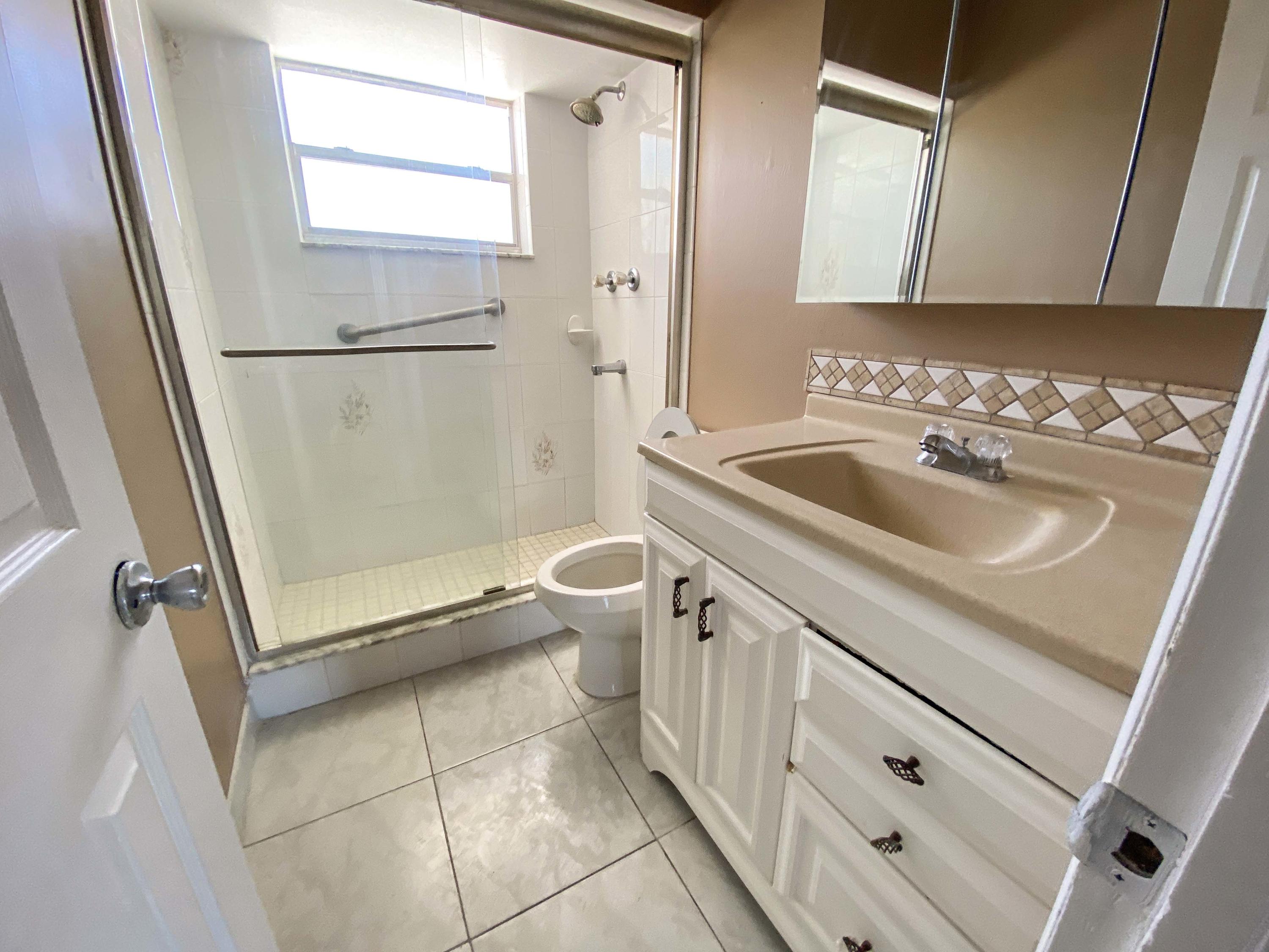 5884 Mango Road, Unit B West Palm Beach, FL 33413 - Photo 6 of 8 a bathroom with a sink a toilet and a mirror