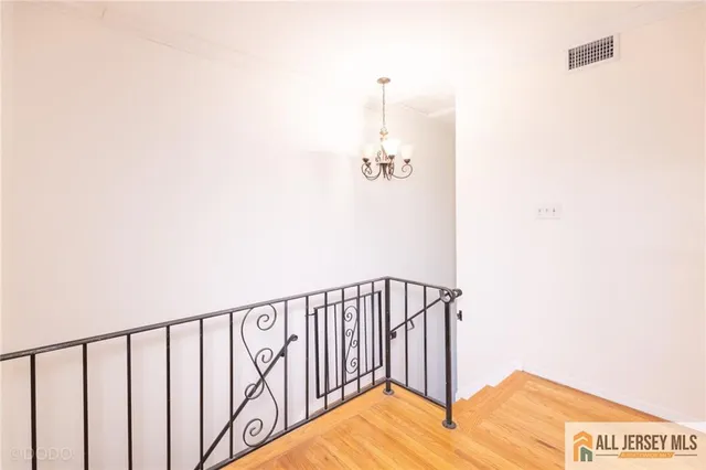 a view of staircase with railing and white walls