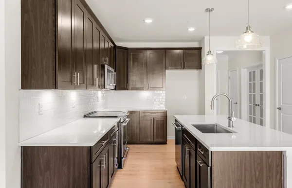 a kitchen with stainless steel appliances granite countertop a sink a oven and a refrigerator