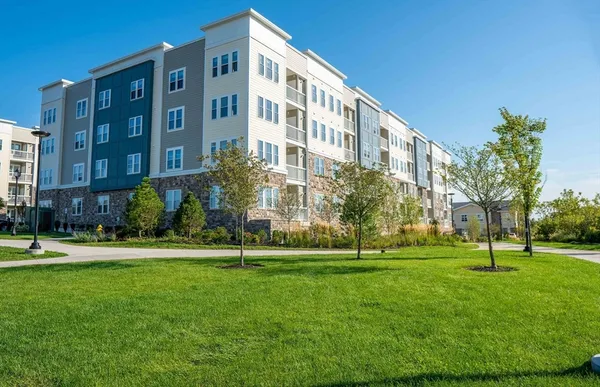 a view of a tall building next to a yard