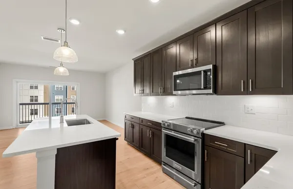a kitchen with stainless steel appliances granite countertop a stove and a sink with cabinets
