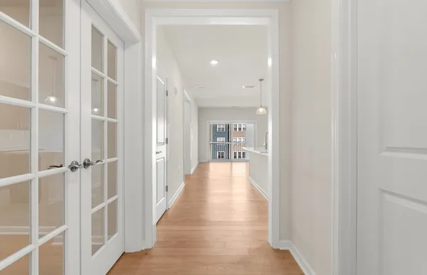 a view of a hallway with wooden floor and staircase