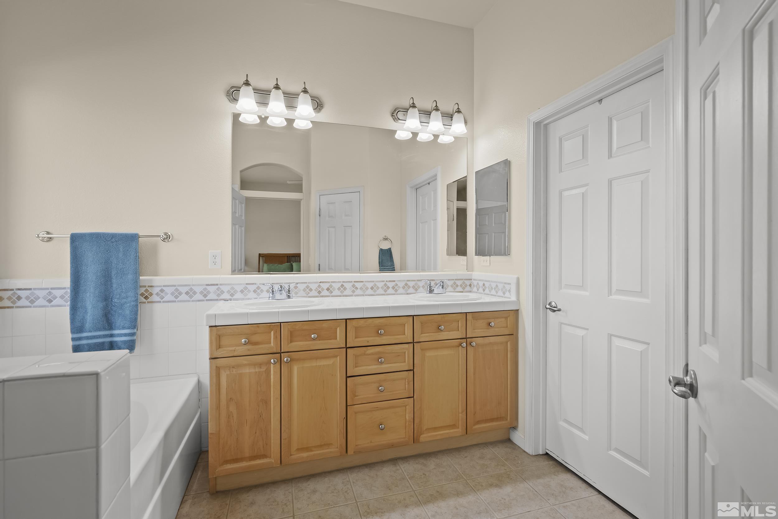 1615 Sewell Drive Reno, NV 89521 - Photo 14 of 25 a bathroom with a granite countertop sink a large mirror and a shower