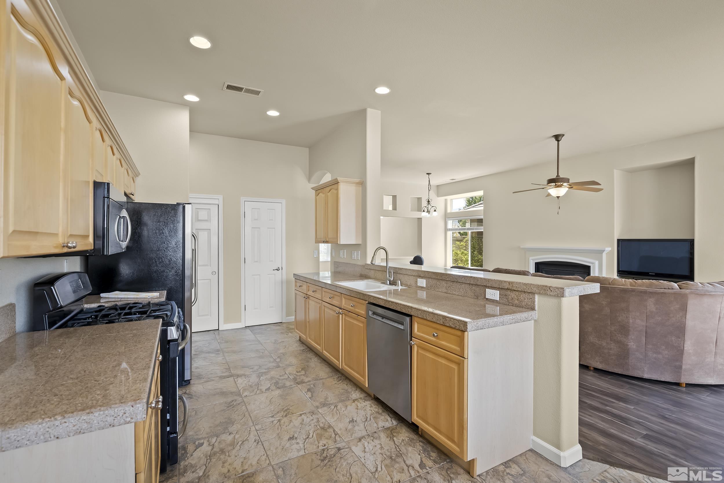 1615 Sewell Drive Reno, NV 89521 - Photo 8 of 25 a kitchen with kitchen island a sink stove and refrigerator