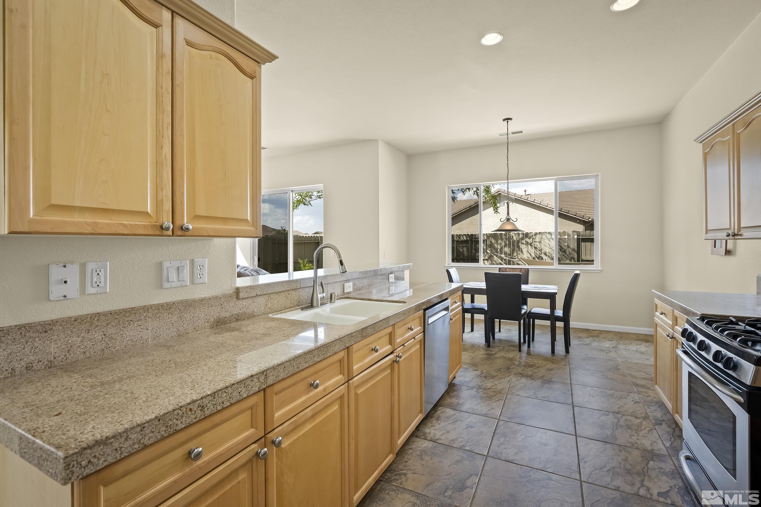 1615 Sewell Drive Reno, NV 89521 - Photo 10 of 25 a kitchen with kitchen island granite countertop a sink and cabinets