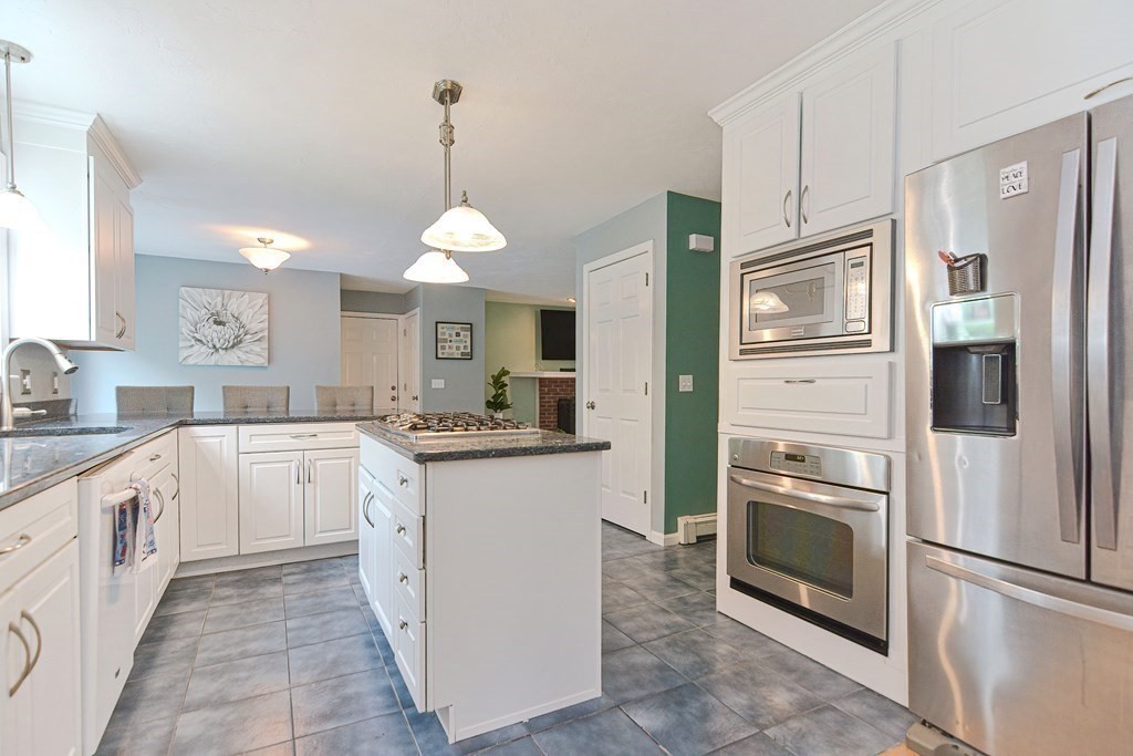 5 Post Road Foxboro, MA 02035 - Photo 12 of 37 a kitchen with white cabinets and stainless steel appliances