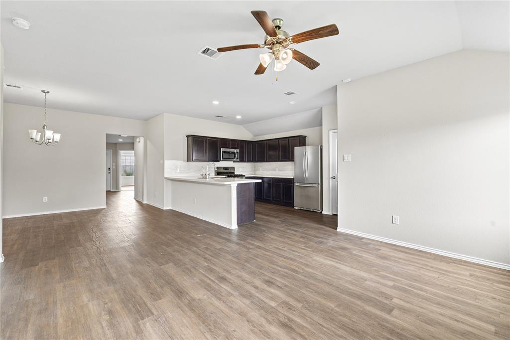 15454 Arce Rojo Street Channelview, TX 77530 - Photo 32 of 32 Kitchen with open floor plan, dark brown cabinetry, vaulted ceiling, a peninsula, and light countertops