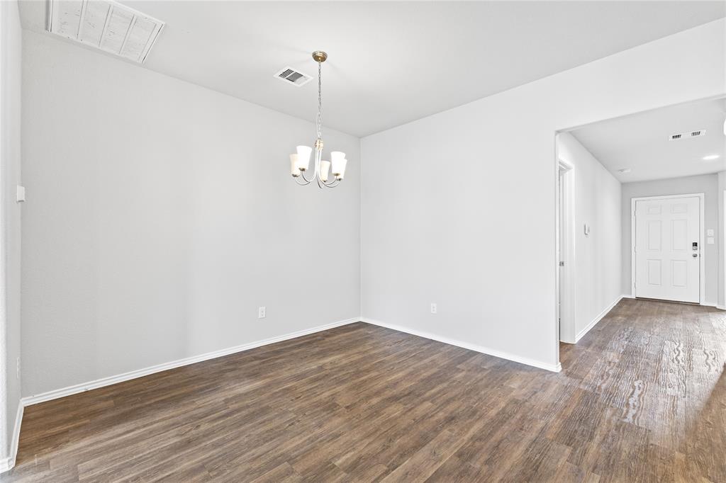 15454 Arce Rojo Street Channelview, TX 77530 - Photo 9 of 32 Unfurnished room featuring a chandelier and dark wood-type flooring