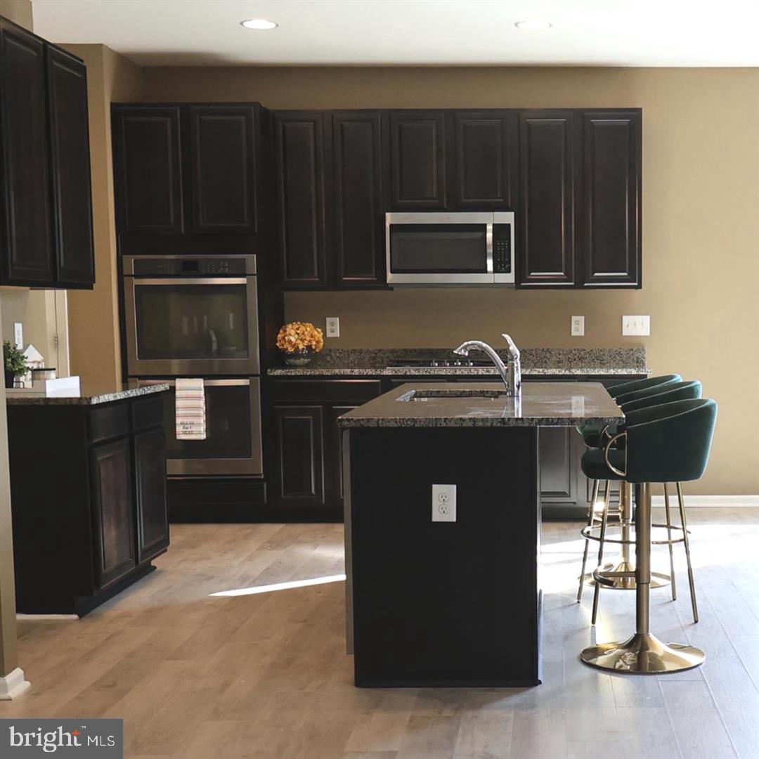 404 Leo Lane Bear, DE 19701 - Photo 3 of 18 a kitchen with granite countertop a refrigerator stove and microwave