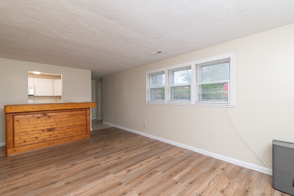 24 Bettys Pond Road, Unit K Barnstable, MA 02601 - Photo 4 of 16 an empty room with wooden floor and windows