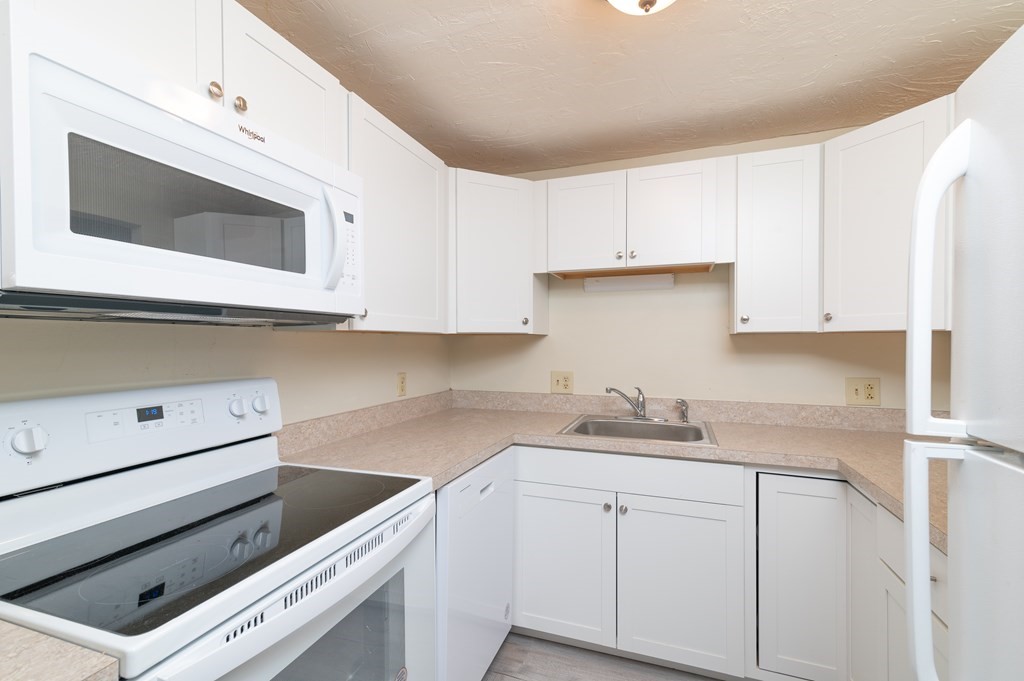 24 Bettys Pond Road, Unit K Barnstable, MA 02601 - Photo 7 of 16 a kitchen with stainless steel appliances white cabinets and a sink