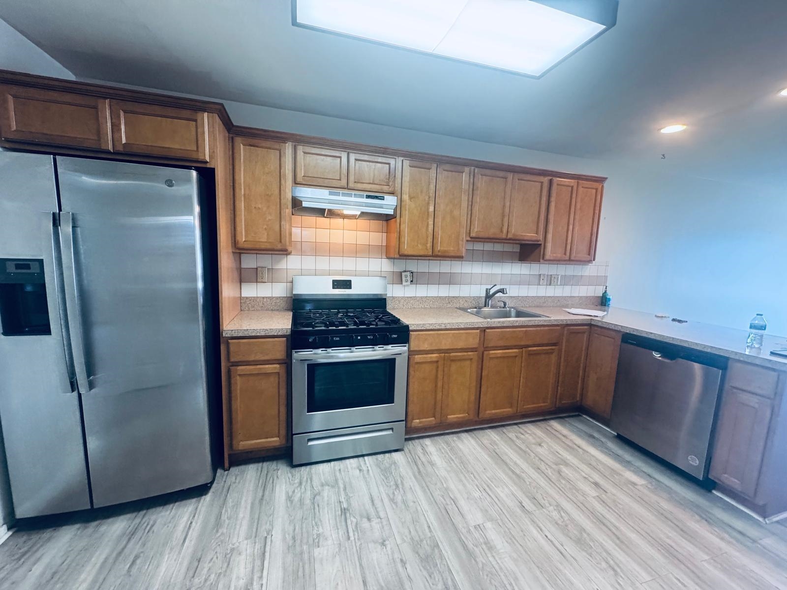 161 West 53rd Street, Unit 2 Bayonne, NJ 07002 - Photo 2 of 19 a kitchen with stainless steel appliances granite countertop a refrigerator a sink dishwasher a stove with wooden floors and cabinets