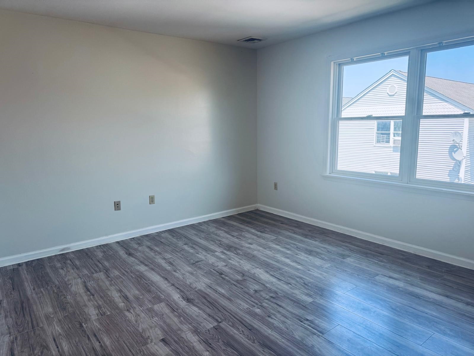 161 West 53rd Street, Unit 2 Bayonne, NJ 07002 - Photo 9 of 19 a view of a room that has wooden floor and windows in it