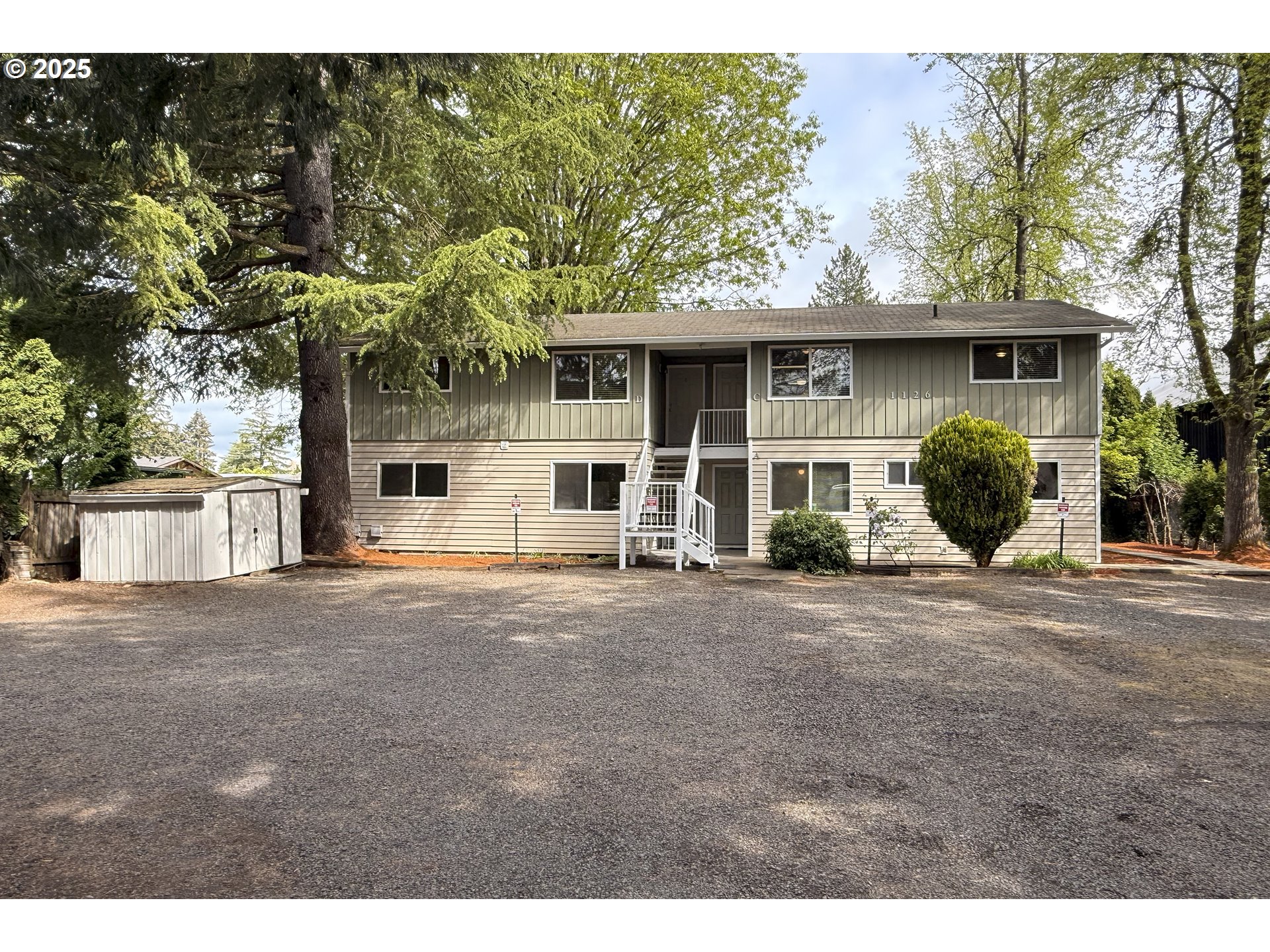 a front view of a house with a garden and plants