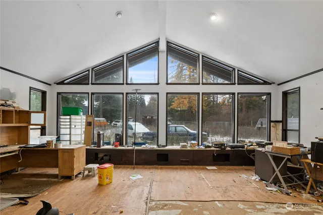 a living room filled with furniture and large windows