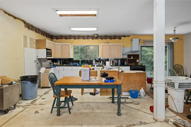 a room with stainless steel appliances kitchen island granite countertop furniture and a view of kitchen