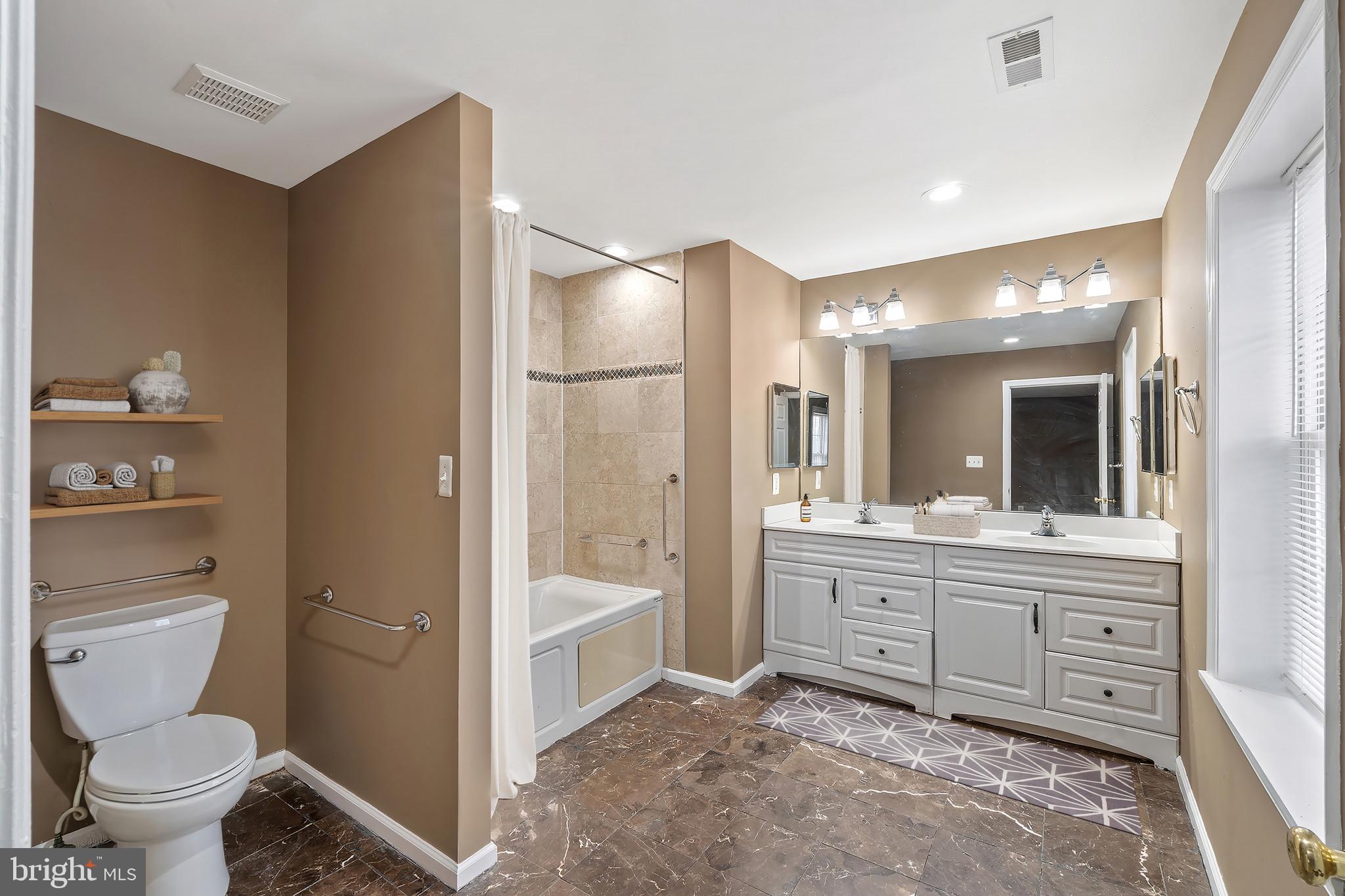 4021 Barrington Road Baltimore, MD 21207 - Photo 29 of 50 a bathroom with a tub sink mirror and toilet