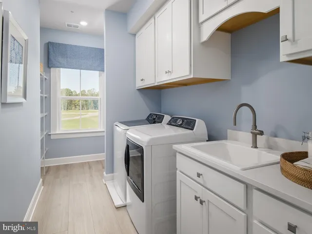 a utility room with sink dryer and washer