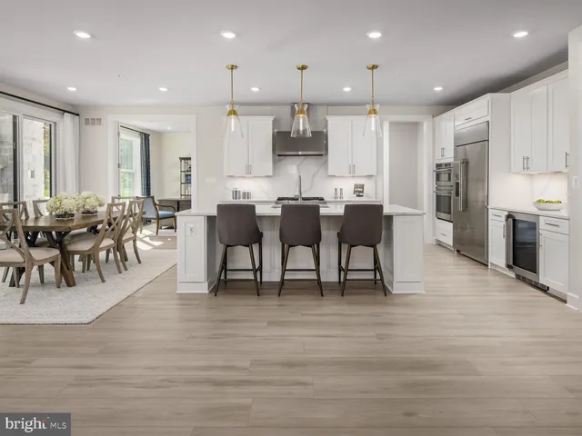 a view of a dining room with furniture wooden floor and a kitchen view