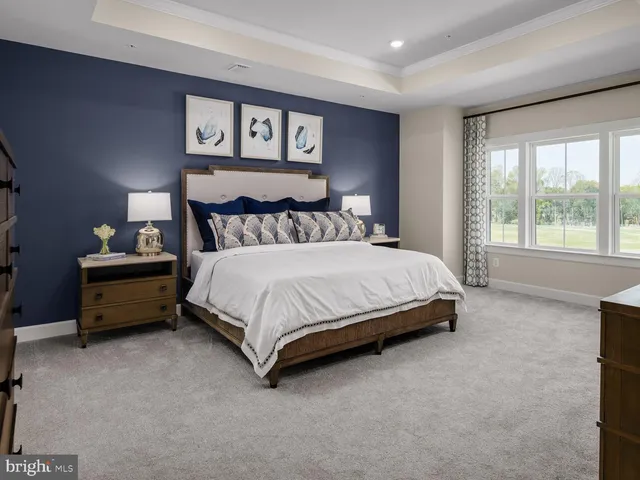 a bedroom with a bed dresser and a large window