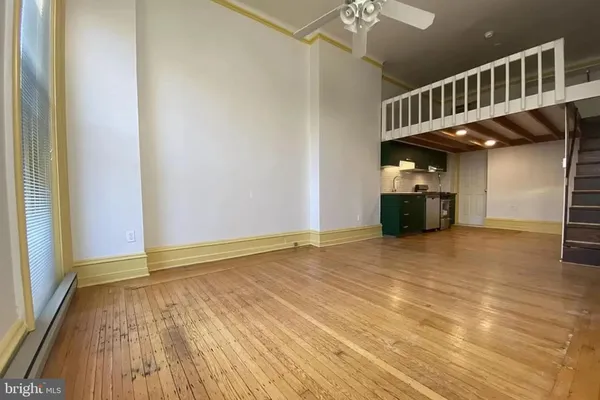 a view of an empty room with wooden floor