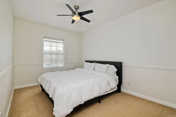 a bedroom with a bed and a ceiling fan