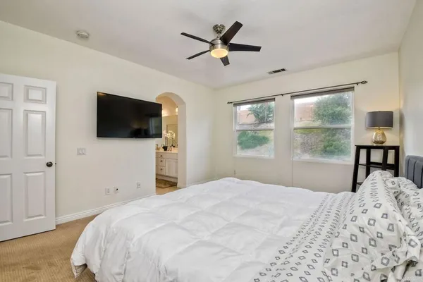 a bedroom that has a bed and a flat screen tv