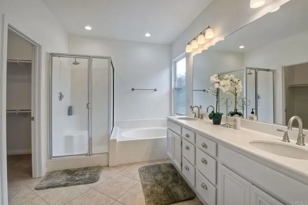 a spacious bathroom with a mirror a double vanity sink and a shower