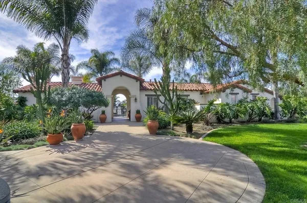 a view of a yard with plants and wooden fence