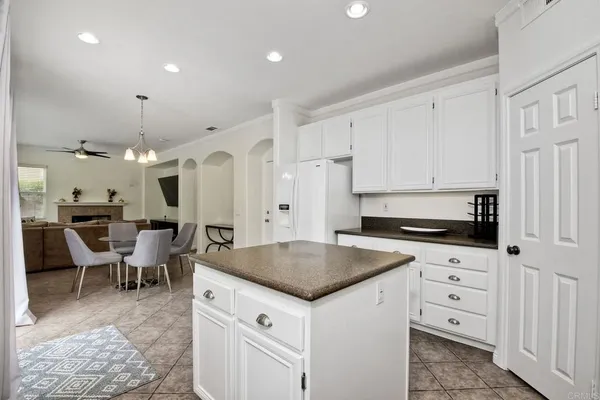 a kitchen with white cabinets and chairs