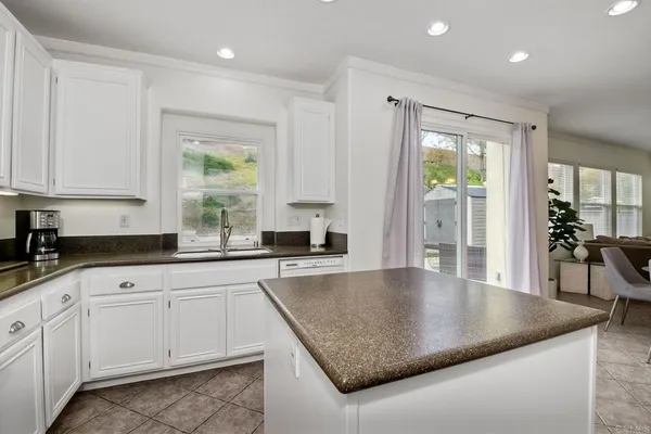 a kitchen with granite countertop a sink a stove and cabinets