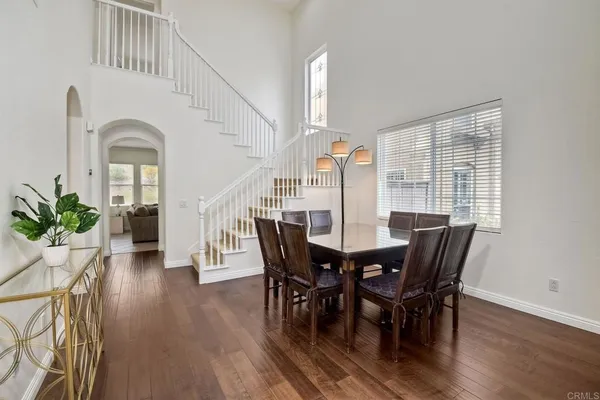 a dining room with furniture potted plants and wooden floor
