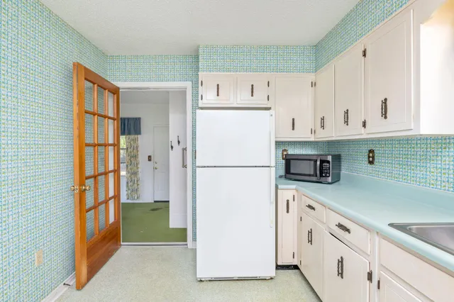 a kitchen with cabinets and a refrigerator