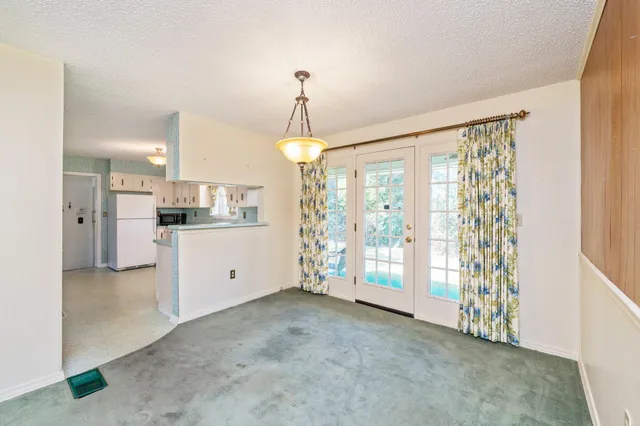 a view of a kitchen with refrigerator and windows