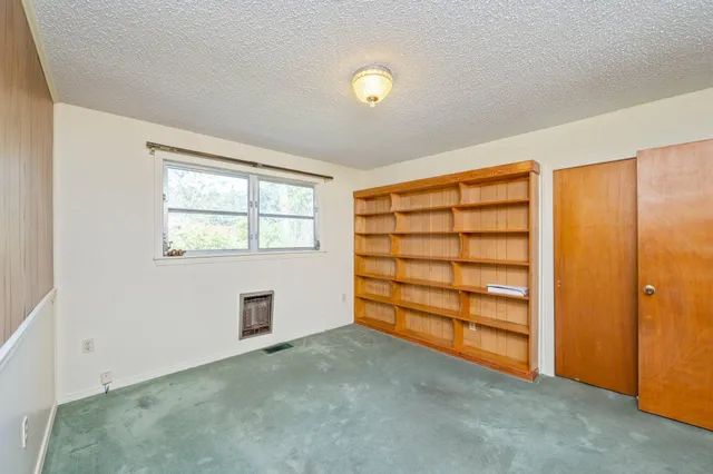 an empty room with furniture and window