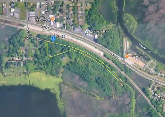 a green field with lots of trees in the background