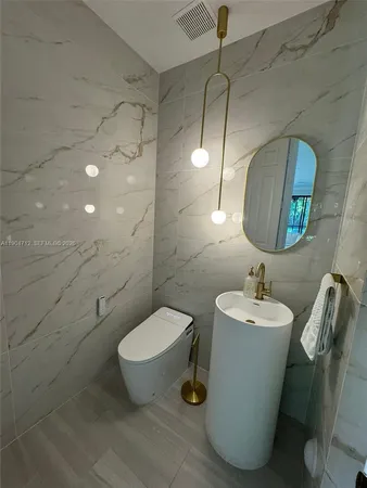 a bathroom with a toilet sink and mirror