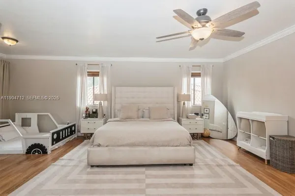 a spacious bedroom with a bed a table and a chandelier