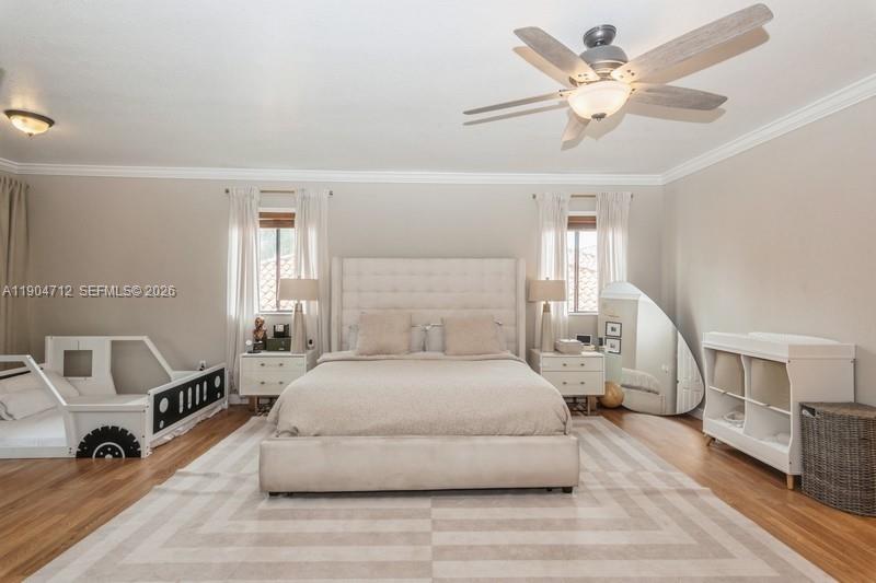 18704 Southwest 76th Court Cutler Bay, FL 33157 - Photo 15 of 47 a spacious bedroom with a bed a table and a chandelier
