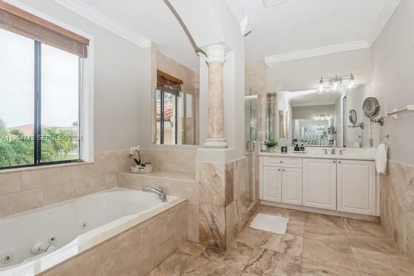 a bathroom with a bathtub a sink a mirror a vanity and a shower