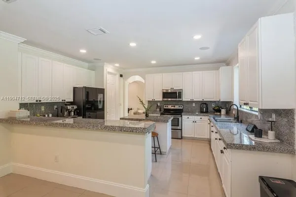 a kitchen with a sink a counter top space stainless steel appliances and cabinets