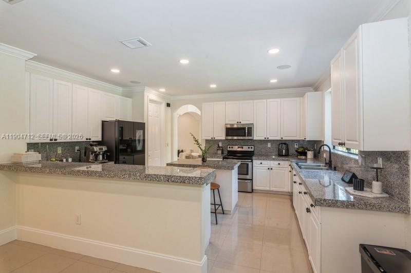 18704 Southwest 76th Court Cutler Bay, FL 33157 - Photo 9 of 47 a kitchen with a sink a counter top space stainless steel appliances and cabinets