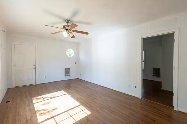 wooden floor in an empty room with a window